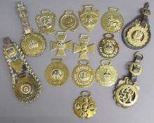 Collection of King George V horse brasses includes enamelled brasses and leather straps