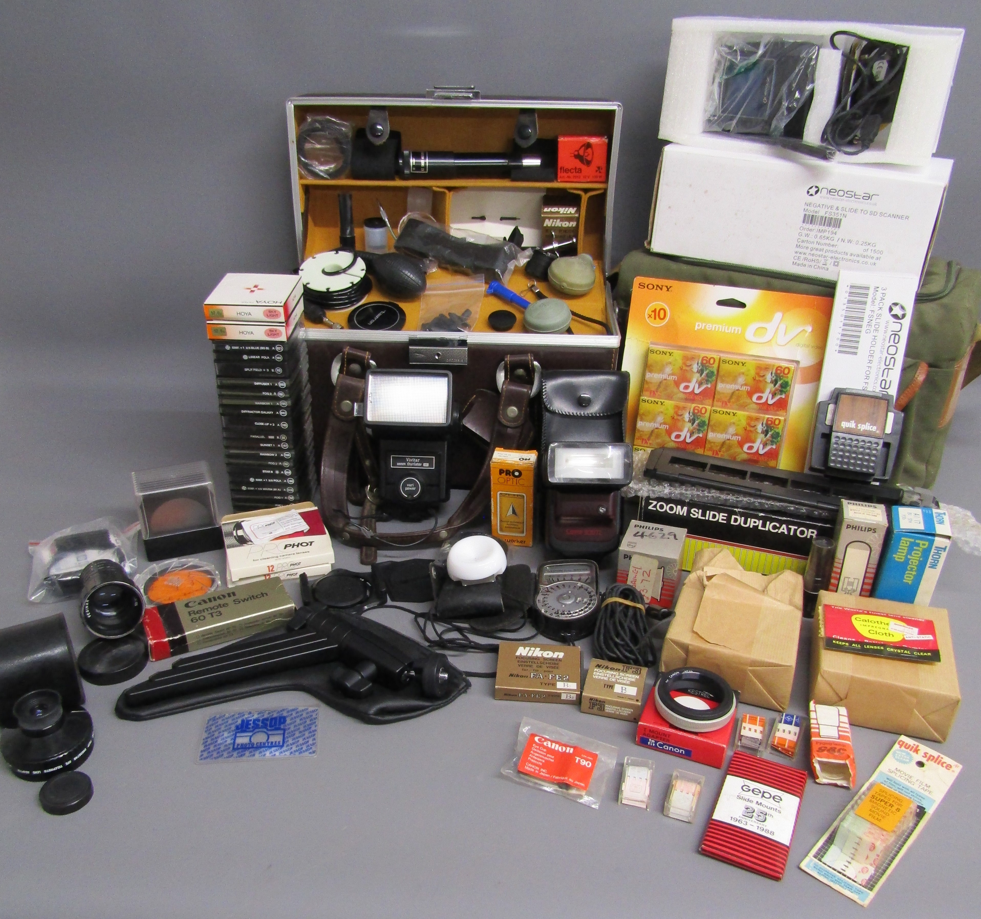 Collection of camera accessories includes Cokin filters, Vivitar zoom thyristor 285 flash, Canon