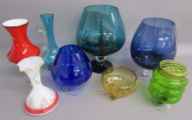 Collection of coloured glass includes over sized brandy glasses, vases, ewers etc