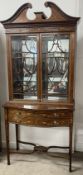 Edwardian inlaid display cabinet with serpentine drawers & swan neck pediment