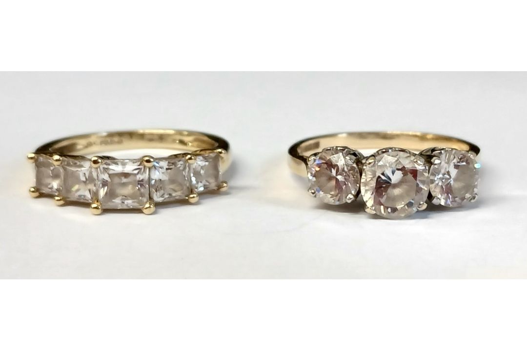 Two 14ct gold (585) cubic zirconia three stone rings, total weight 5.70g