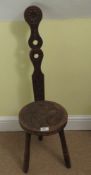 A part carved tripod stool with spoon back.