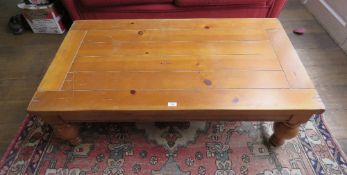 A contemporary pine coffee table raised over baluster legs, 132 x 71 x 44cm.