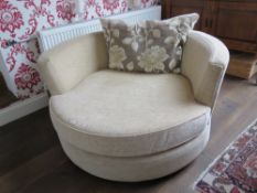A contemporary circular revolving cream upholstered sofa chair, 130cm dia.