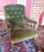 A Victorian button back deep seated fireside elbow chair, raised over ring turned legs.