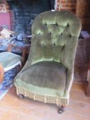 A buttoned high back nursing chair raised over turned legs.