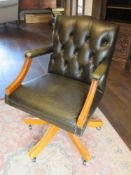 A contemporary green leather button back desk chair, slightly a/f.