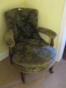 An Edwardian oversprung circular buttoned lounge chair raised over turned legs.