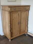 A pine two door cabinet with single drawer over, 96 x 56 x 126cm.
