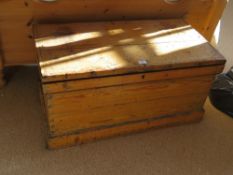 An antique pine blanket box with iron end handles.
