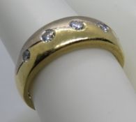 An 18ct white and yellow gold ring set with five round cut brilliant diamonds in rub over settings,