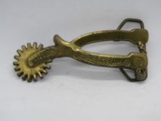 A brass Baron Buckle boot spur themed belt buckle c1980.