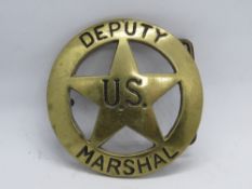 A brass 'Deputy US Marshal' belt buckle, numbered 606 to back.