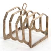 An Art Deco silver toast rack of angular form, four divisions with central loop carrying handle,