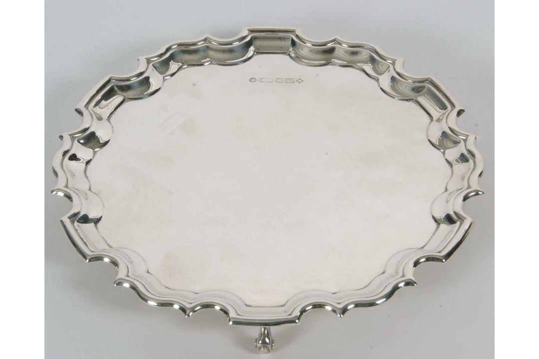 A sterling silver card salver of plain form, having pie crust edge and supported on three cast - Image 1 of 3