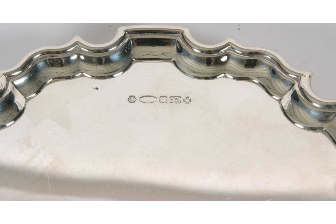 A sterling silver card salver of plain form, having pie crust edge and supported on three cast - Image 2 of 3