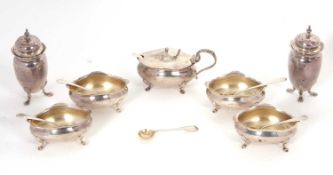 A seven piece silver condiment set comprising of four oval open salts with wavy rims, two hallmarked