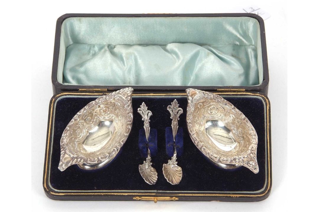 A cased late Victorian pair of boat shaped pedestal salts, floral scroll embossed together with - Image 1 of 2