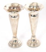 Pair of George V silver trumpet vases having wavey rims and tapering stems to a loaded stepped base,
