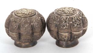 A pair of 19th Century Malaysian white metal betel nut boxes of floral design
