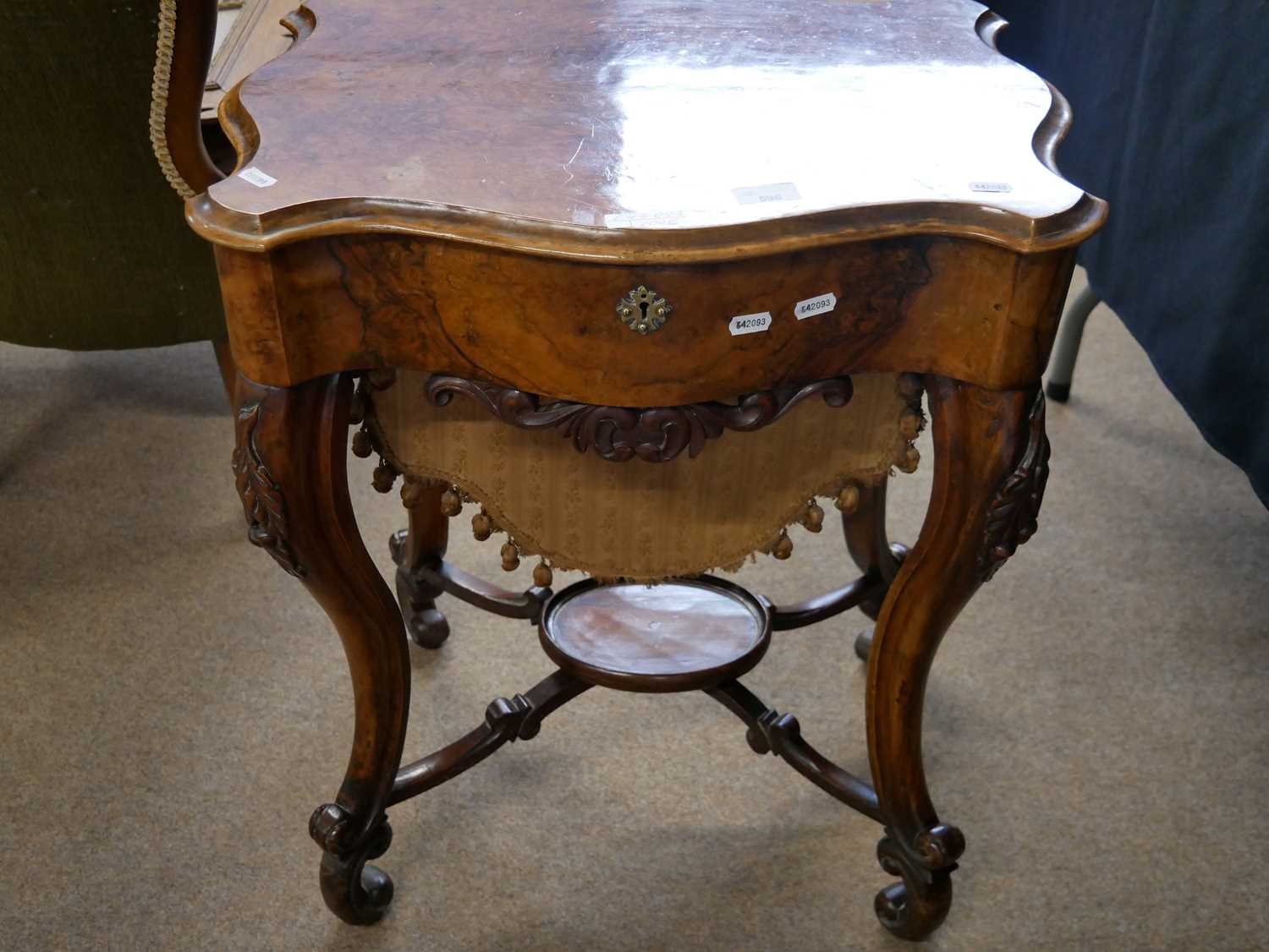 Victorian walnut veneered sewing table of serpentine form, raised on tapering cabriole legs, with