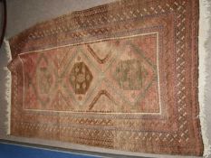 Late 19th/early 20th century Middle Eastern wool floor rug in heavily faded condition, the central