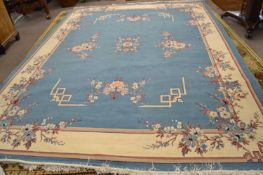 A large 20th Century light blue and cream ground wool floor rug with floral spray decoration