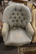 A Victorian armchair with pale blue and floral buttoned upholstery and short scrolled legs, 90cm
