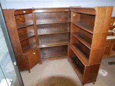 An unusual Minty oak three section corner bookcase with open fronts, each section formed of stacking