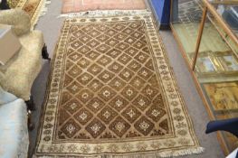 A small Middle Eastern wool floor rug with large central geometric panel mainly in beige and