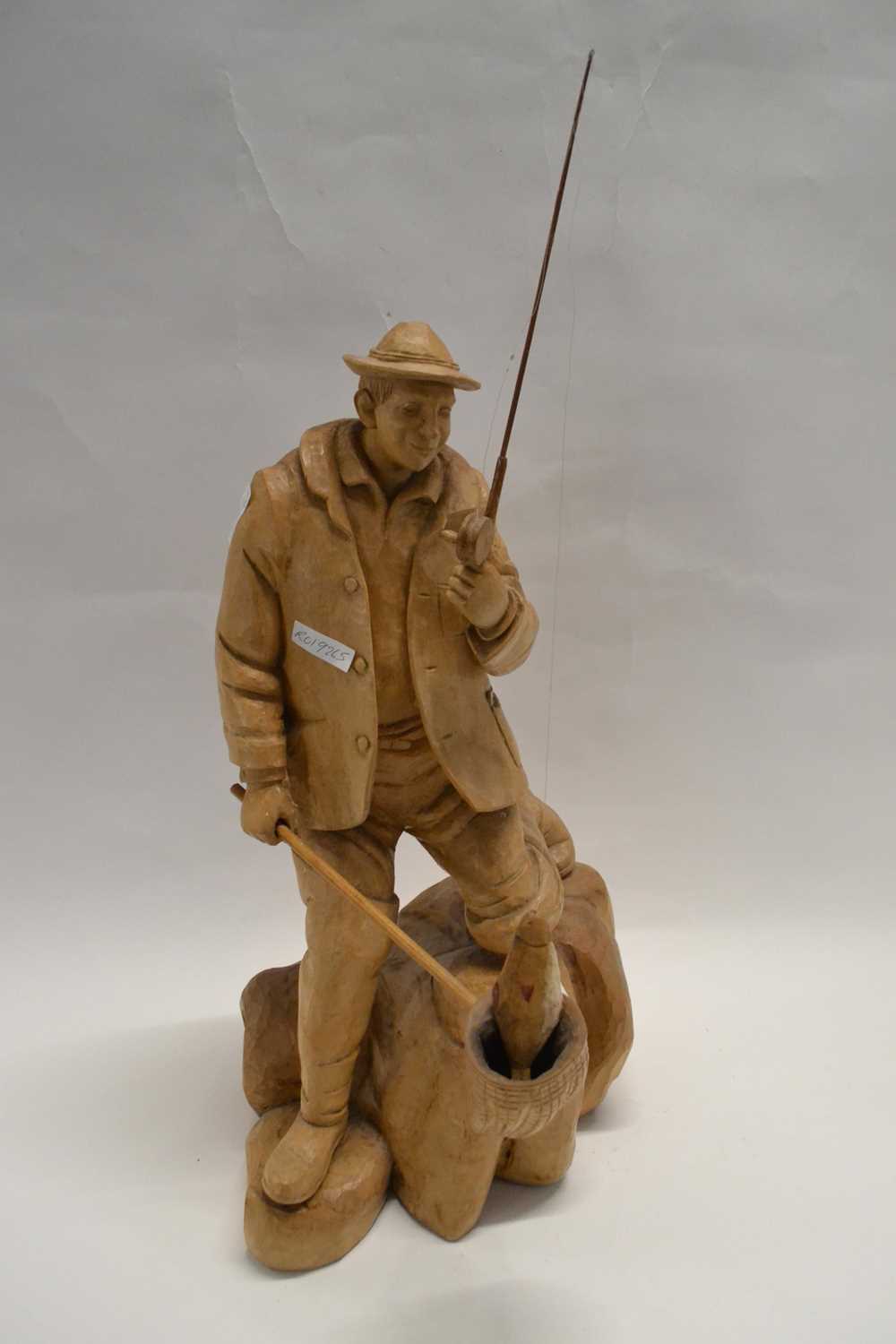 An impressive carved wooden model of a fisherman on moulded base, 57cm high