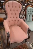 A Victorian mahogany framed armchair with buttoned upholstery and scrolled front legs