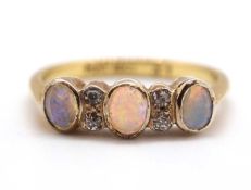 An opal and diamond ring, the three oval opal cabochons interspaced with two small single diamonds
