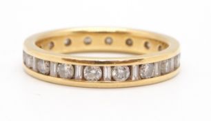 An 18ct diamond eternity ring, the full hoop ring channel set with alternating round brilliant cut