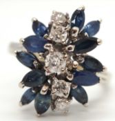 An 18k sapphire and diamond ring, set with a line of five round brilliant cut diamonds and a spray