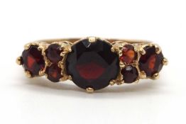 A 9ct garnet ring, the three principal graduated round garnets interspaced with small round garnets,