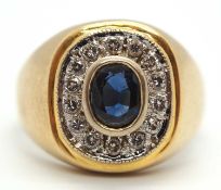 A gentlemans sapphire and diamond ring, the central oval collet mounted sapphire, surrounded by