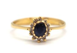 A sapphire and diamond cluster ring, the central oval sapphire surrounded by small round diamonds,