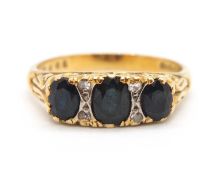 An 18ct sapphire and diamond ring, the three graduated off-round sapphires interspaced with
