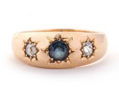 An 18ct sapphire and diamond ring, the central round sapphire set to either side with an old mine