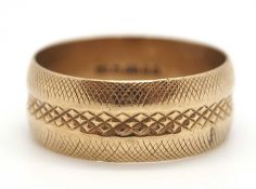 A 9ct wedding band, the 7mm wide band with textured decoration, hallmarked London 1984, size P, 4.