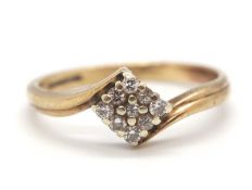 A diamond crossover ring, the central square plaque set with small round diamonds, set to a