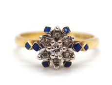 An 18ct diamond and blue enamel ring, the starburst style cluster set with a single round