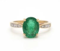 A 9ct emerald ring, the oval emerald, approx. 9mm long, in a four claw mount, with diamond