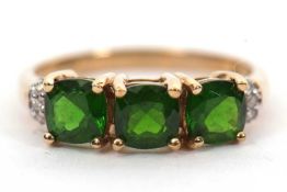 A 9ct diopside and diamond ring, the square mixed cut diospsides with three diamond highlights to