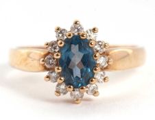 A 9ct topaz and diamond cluster ring, the oval topaz surrounded by small round brilliant cut