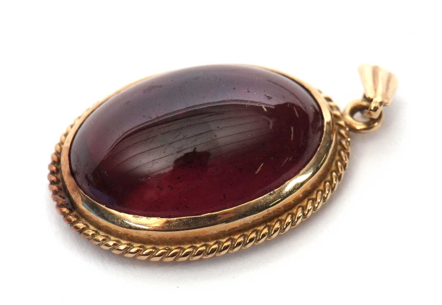 A garnet pendant, the oval garnet cabochon in collet mount with rope twist border and tapered - Image 2 of 4