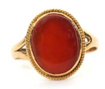 An unmarked agate ring, the oval agate cabochon, with closed back, split shoulders and plain band of