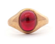 A 9ct garnet ring, the oval garnet cabochon in collet mount with tapered shoulders and plain band