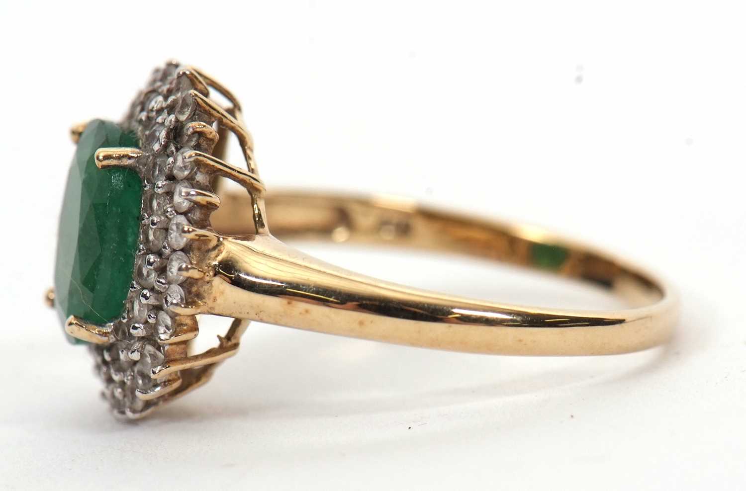 A 9ct emerald and diamond cluster ring, the oval emerald, approx. 9mm long, surrounded by two rows - Image 2 of 6